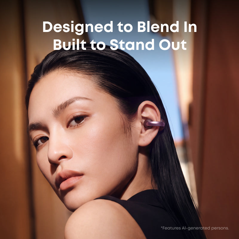 A close-up lifestyle shot of a woman with long dark hair wearing Anker Soundcore Aeroclip 2. The image features promotional text reading 'Designed to Blend In Built to Stand Out' and a small disclaimer at the bottom right.